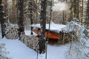Северная стена, подвешенный на зиму каяк, заготовленные дрова. 